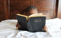 photo of child reading holy bible