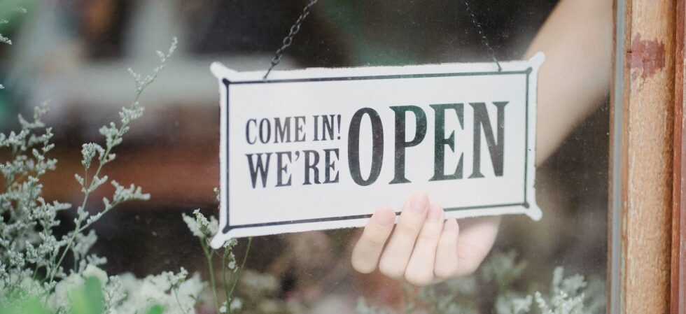 crop person showing signboard on window