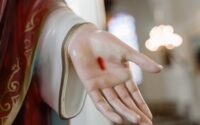 person in red long sleeve shirt holding womans hand