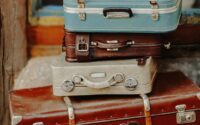 vintage suitcases stacked outdoors near storefront
