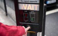 photo of person pressing the button of pedestrian box
