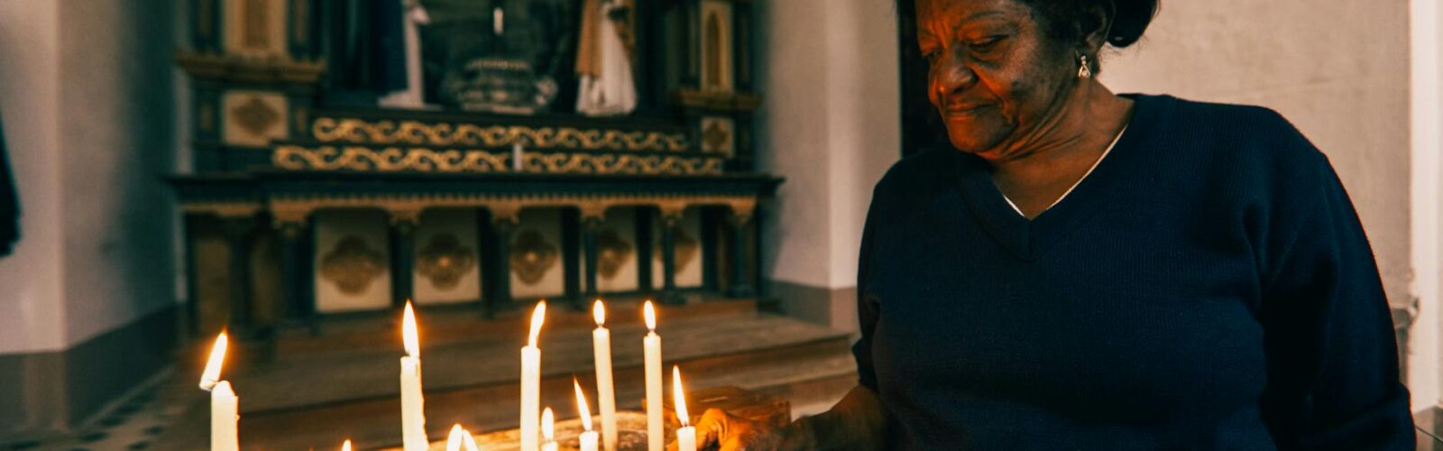 woman lighting candle in church