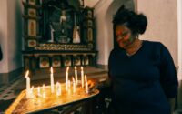 woman lighting candle in church