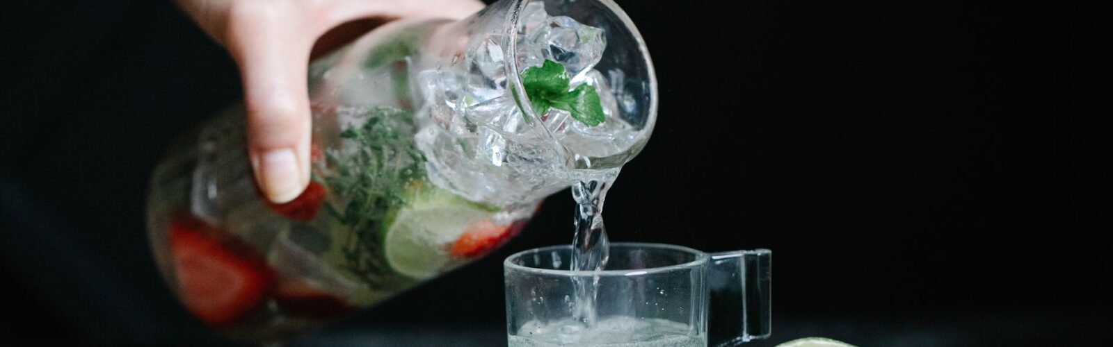 person pouring a drink in a cup