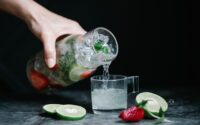 person pouring a drink in a cup